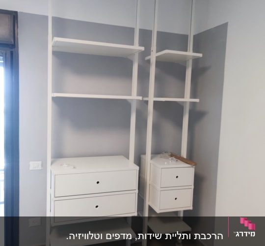 מדפים לבנים מותקנים על קיר עם מגירות